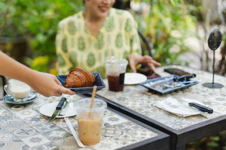 Waitress serving croissants in the coffee shop outdoor.の写真素材