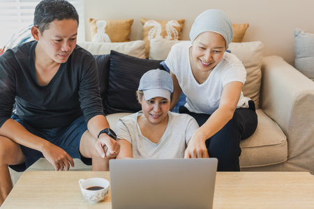 hree colleagues working on laptop at home.の写真素材