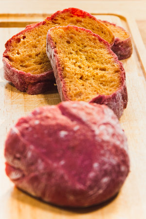 Homemade beetroot Italian ciabatta bread cut in slices on wooden board.の写真素材