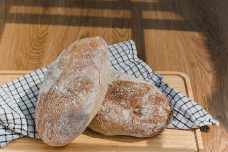 Loaf of freshly homemade artisan bread on wooden board.の写真素材