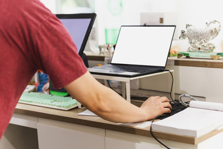Owner restaurant working on laptop computer at cashier counter.