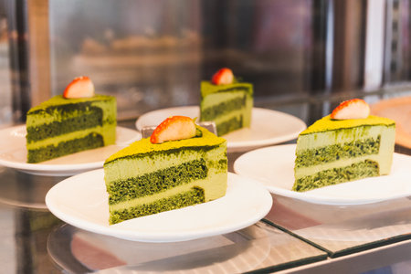 Delicious slice matcha green tea cake showing in cake shopの写真素材