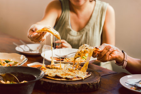 Woman hands taking slices of pizza with friends.の写真素材