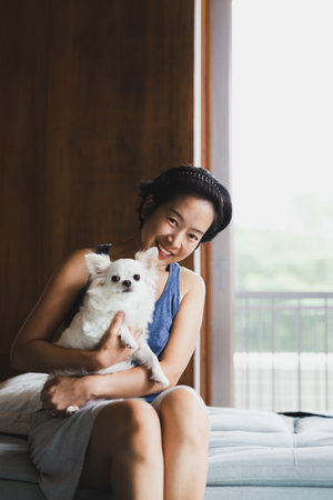 Vertical of woman beautiful holding a cute white small dog.