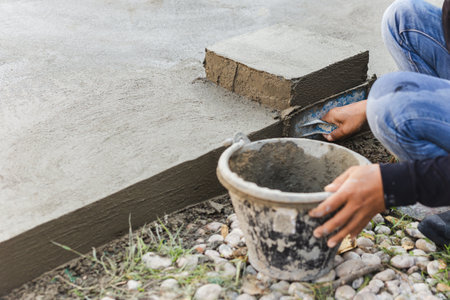 Worker leveling concrete cement floor using trowelの写真素材
