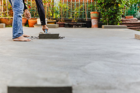 Worker leveling concrete cement floor using trowelの写真素材