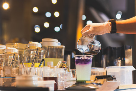 Man making butterfly tea with yuzu juice in a tak away glassesの写真素材