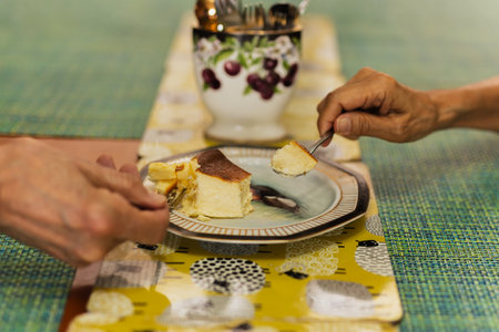 Senior couple hands with spoon eating burnt cheesecakeの写真素材