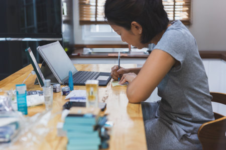 Asian woman marketing checking order online working on laptop computer at home.