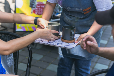 Waitress serving fresh hot coffee in cafe outdoorsの写真素材