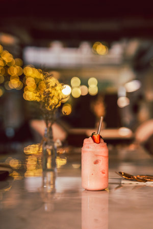 Strawberry milkshake with slice of strawberries on tableの写真素材