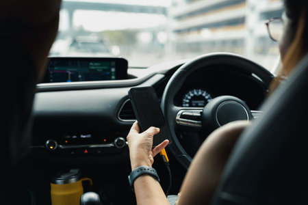 Woman using her cellphone while driving a carの写真素材