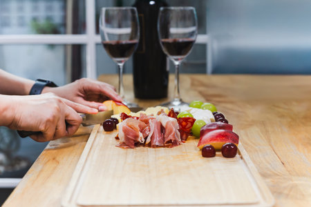 Arrangement of cold cuts with smoked Ham and Cheese on wooden boardの写真素材