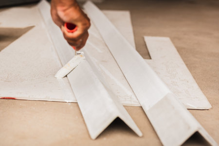Plaster hand sanding a bathroom wall using sandpaper