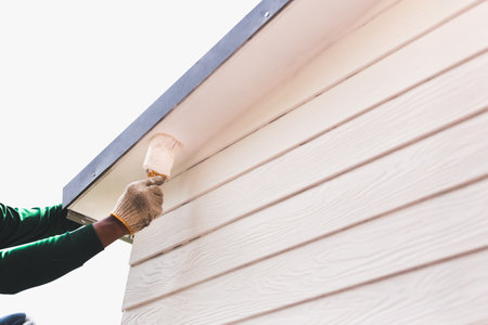 Painter painting a house roof with white paintの写真素材