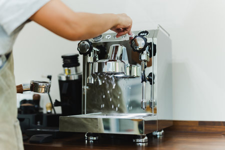 Woman barista hand pressing the water to flus a coffee machineの写真素材
