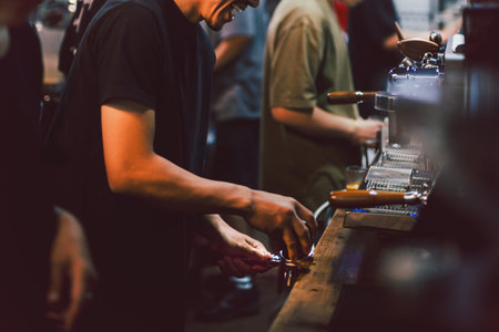 Narrow shot in low light of barista making a fresh coffee in cafe
