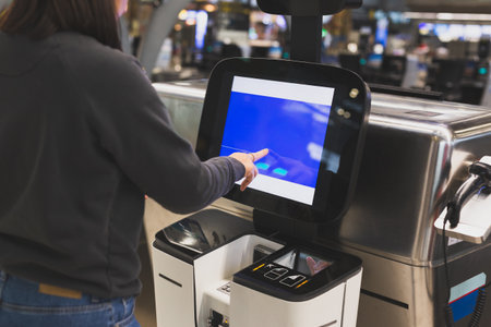 Woman using service machine for self check in at airportの写真素材