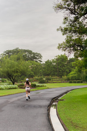 Woman runner running in park nature exercising in summerの写真素材