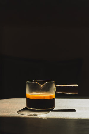Espresso coffee in a glass cup on a dark background in vertical