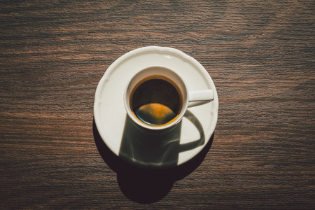 Espresso in a cup on a wooden table top viewの写真素材