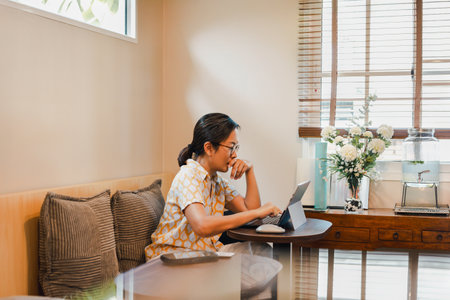 Woman hand cover her mouth while working on laptopの写真素材
