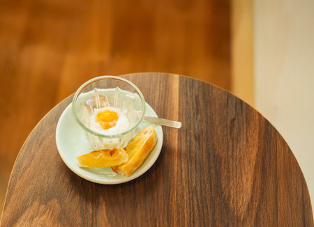 Top view of soft boiled egg with slice of toast on wooden table.の写真素材