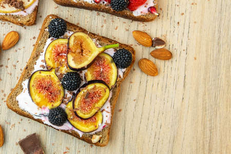Healthy breakfast. Slice of wholegrain toast with cream cheese, figs, nuts and BlackBerry. Top view.の写真素材