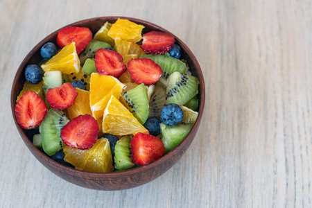 Healthy fresh fruit salad in bowl on light background.の写真素材