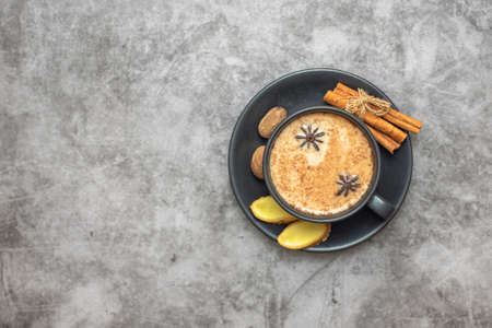 Cup of traditional indian masala chai tea with ingredients. Cinnamon, cardamom, anise, nutmeg. With copy space. Top view.の写真素材