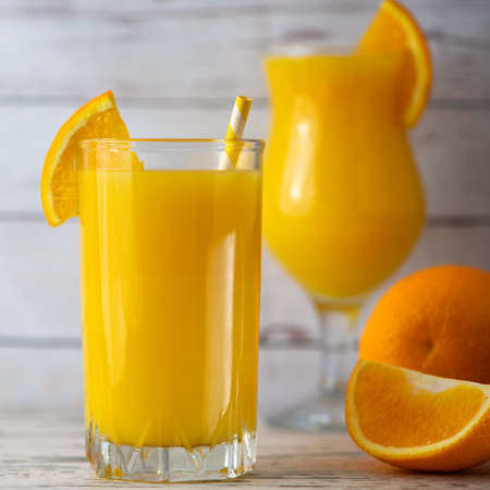 Glasses of Fresh Orange Juice on light wooden background. Side view.の写真素材