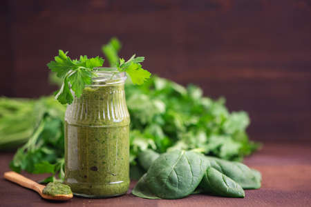 Two Spinach smoothies. Healthy green juice with ingredients on light wooden table. Side view.の写真素材