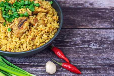 Rice pilaf with meat carrot and onion on wooden background.