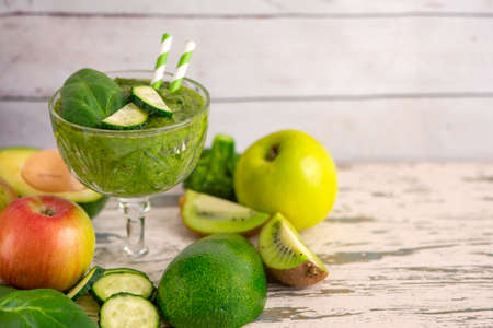 Green smoothies with ingredients on light wooden table. Side view.の写真素材