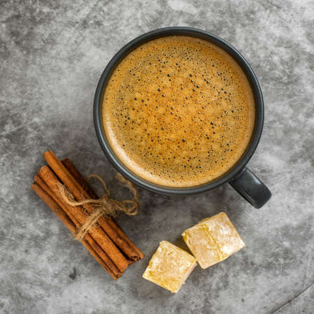 Cup of coffee with cinnamon stick and turkish delight on gray background. Top view.の写真素材