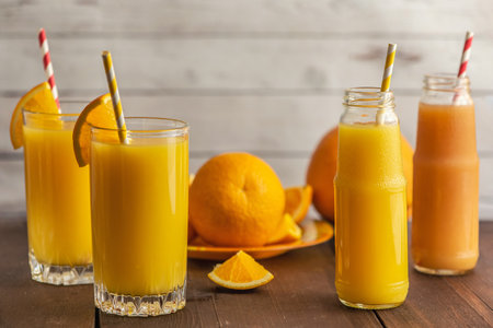 Glasses of Fresh Orange Juice on light wooden background. Side view.の写真素材