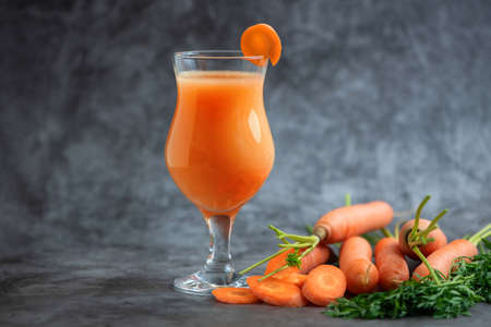 Glasses of carrot juice with vegetables on gray table. Side view.の写真素材