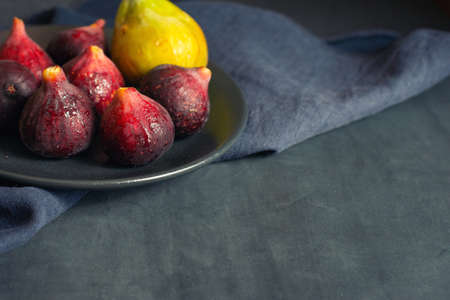 A few figs in a black plate on an dark background with copy space.の写真素材