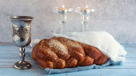 Shabbat Shalom - challah bread, shabbat wine and candles on wooden table.の写真素材
