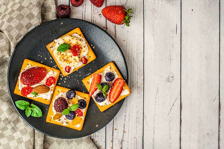 Set of crackers with various fruit close-up on light wooden background. Top view, with copy space.の写真素材