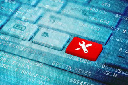 Red key with work tools icon on blue digital laptop keyboard.