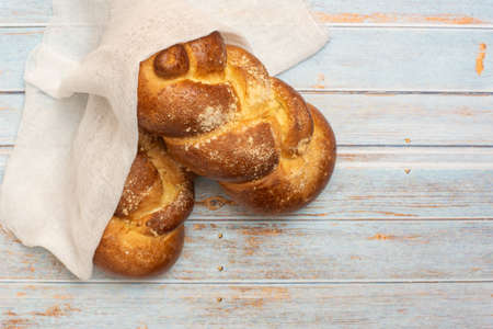 Shabbat Shalom - challah bread on blue wooden background. Top view.