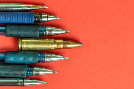 Bullet and pens on red background. Freedom of the press is at risk concept. World press freedom day concept.の写真素材