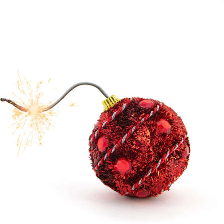 Christmas tree decoration. Red bomb ready to go off with golden sparkles on white background. New Year concept.の写真素材