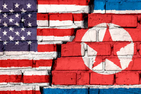 Flags of USA and North Korea on the brick wall with big crack in the middle. Symbol of problems...