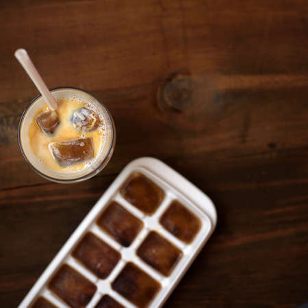 frozen coffee cubes with milk - cocktails on dark wooden table. Top view.