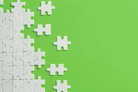 White details of puzzle on green background.の写真素材