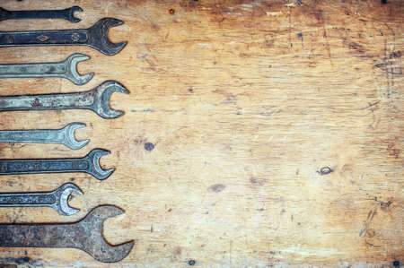 Old vintage wrenches on wooden background. Top view. With copy space.の写真素材