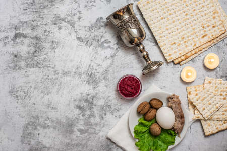 Jewish holiday Passover background with wine, matza and seder plate on gray background. Top view. With copy space.の写真素材
