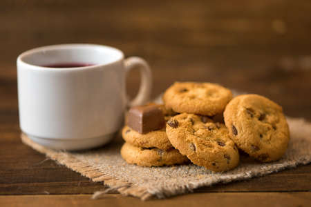 White cup of tea and cookies on dark wooden background.の写真素材